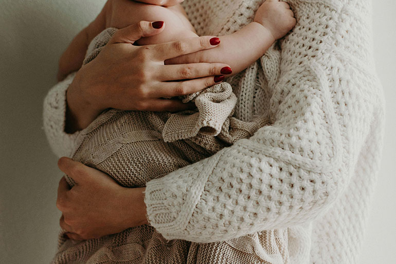 mother holding her child at postpartum appointment 